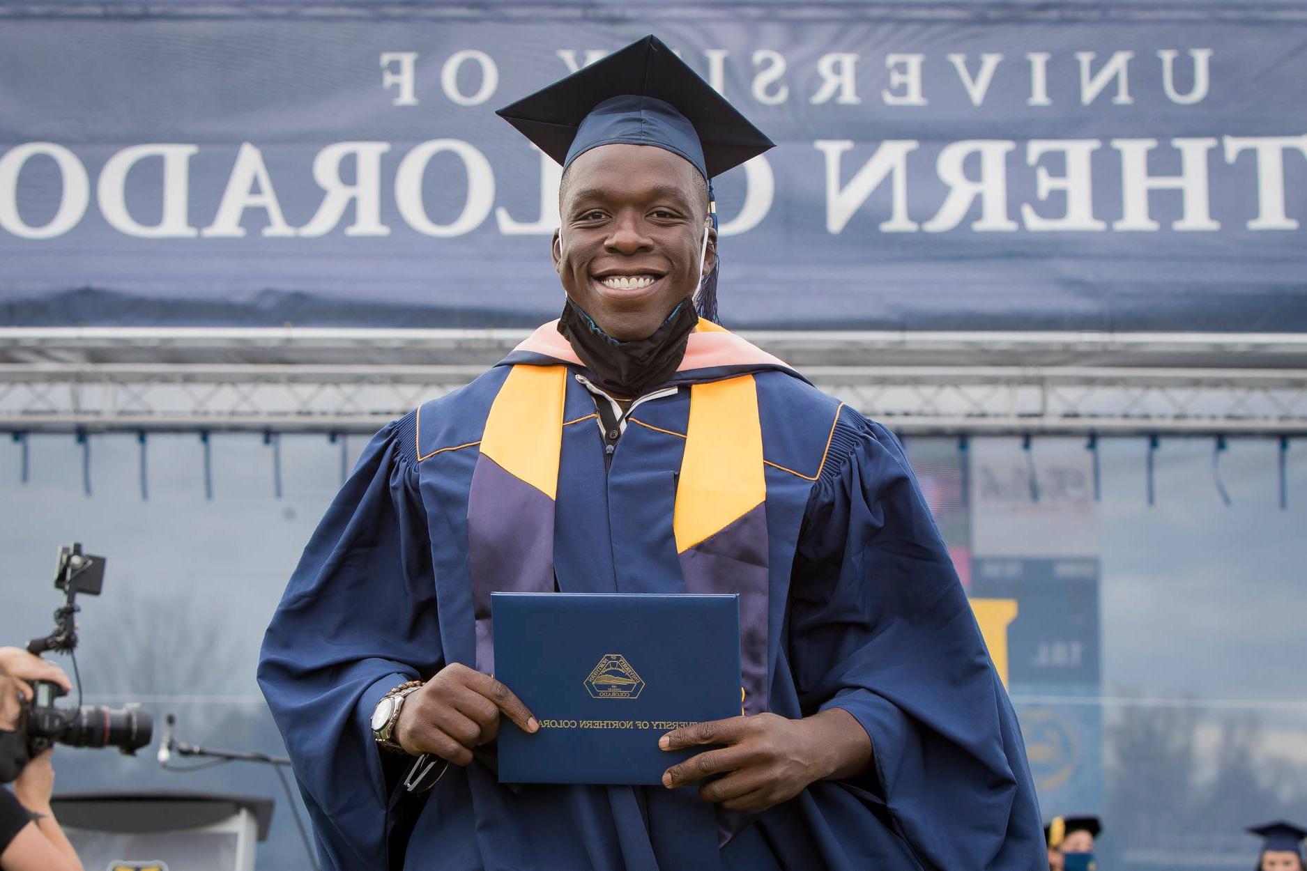 科罗拉多公共卫生学院的学生Fisayo Awolaja正在接受毕业证书. 最佳研究生院2023美国皇冠app安卓下载安装标志在图像的左上角. 